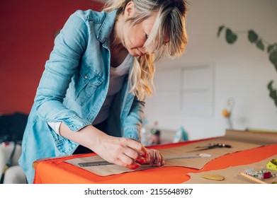 Concentrated Middle Aged Woman Tailor Using Pattern Dress Detail And Creating A Sketch Lines With Chalk For Sewing Machine. Workplace Of A Dressmaker. Handmade Concept.