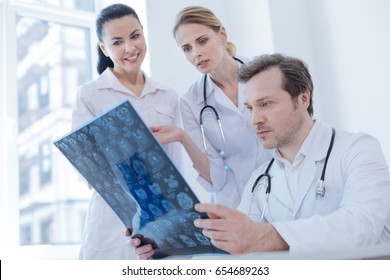 Concentrated neurologist examining brain x ray image indoors