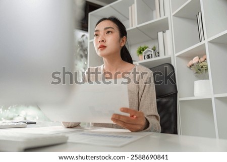 Concentrated office worker contemplating data and reports while managing stress in a professional setting.