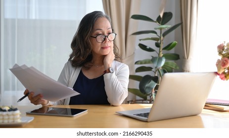 Concentrated Older Mature Woman Watching Webinar Or Working Online On Computer Laptop At Home