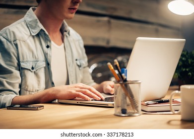 Concentrated On Work. Close-up Of Confident Young Man Working Late While Sitting At His Working Place 