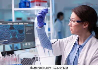 Concentrated professional woman scientist in laboratory working with test tube. Biology doctor discovery scientifc experiment with professional technology equipment industry