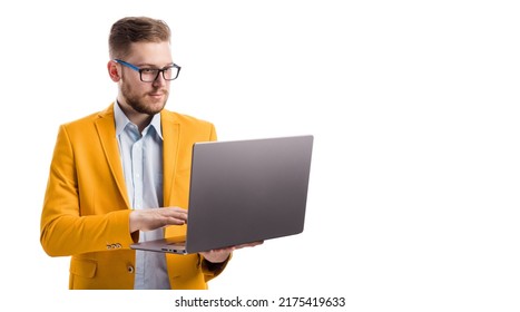 Concentrated serious businessman working online with copy space in white studio. Focused young professional entrepreneur web surfing on modern wireless laptop. - Shutterstock ID 2175419633