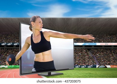 Concentrated sportswoman practising discus throw against american football arena - Powered by Shutterstock