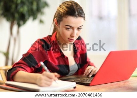 Concentrated student e-learning using laptop and taking notes at home
