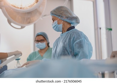Concentrated surgical team working with a patient in an operation room - Powered by Shutterstock