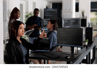 Concentrated web developer working with hologram and coding language in programming it office room. System engineer analyzing holographic script and augmented reality to develop new server interface. - Powered by Shutterstock