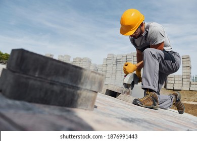 Concentrated At Work. Man In Yellow Colored Uniform Have Job With Pavement.