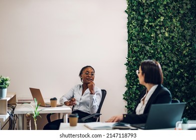 Concentrated Young African American Business Woman Working On A Laptop While Sitting At The Table In The Office. Confident Business Expert. E-commerce, Internet Technology Or Small Business Concept.