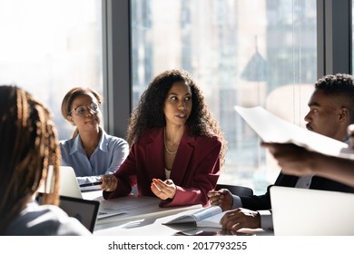 Concentrated Young African American Female Leader Boss Negotiating Business Ideas Or Developing Project Growth Ideas With Motivated Mixed Race Employees Workers Managers At Brainstorming Meeting.