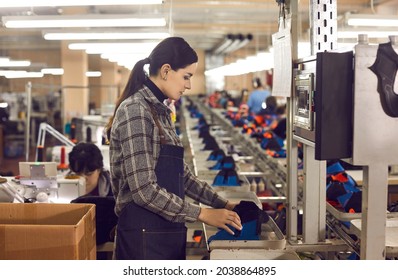 Concentrated Young Female Manufacturing Workshop Worker Making Shoe At Mass Production Line Of Footwear Factory. Woman Shoemaker Using Machine Equipment. Profession And Industry Concept