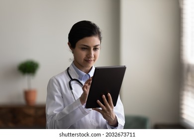 Concentrated Young Indian Female Doctor General Practitioner Therapist Using Applications On Digital Tablet, Consulting Patient Online, Prescribing Treatment Distantly, Medicine And Modern Tech.