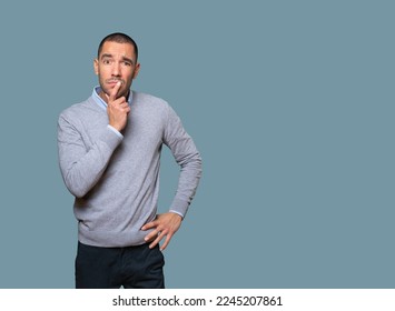Concentrated young man making a gesture of distrust - Shutterstock ID 2245207861