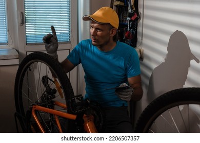 Concentrated Young Man Mechanic Repairing His Mountain Bike At Home