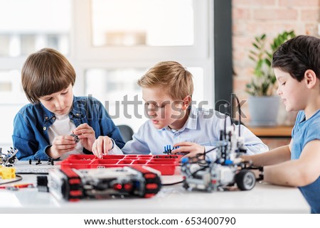 Concentrated young technician using certain details