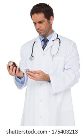 Concentrating Doctor Reading Label On Medicine Jar On White Background