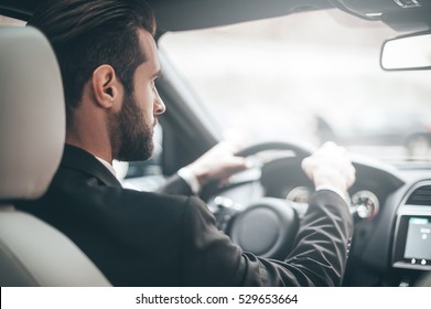 Concentrating On The Road. Rear View Of Young Handsome Man Looking Straight While Driving A Car 