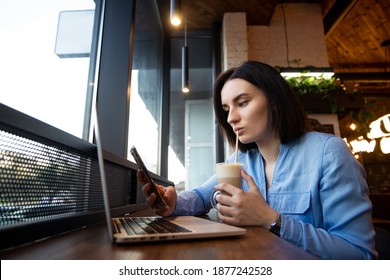 Concentration Problems Concept. Upset Young Woman Looking In Smartphone And Scrolling. Social Media Concept. Cafe Or Restaurant On Background. Young Female Freelancer Drinking Latte.