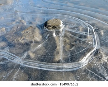 Concentric Lines Around A Rock Protruding From A Frozen Puddle. All Gone 2 Hours Later. Whitehorse, March 24, 2019.