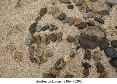 Concentric structure of stones on the sand, top view, close-up, concentration, contemplation, texture.                                - Shutterstock ID 2186478295