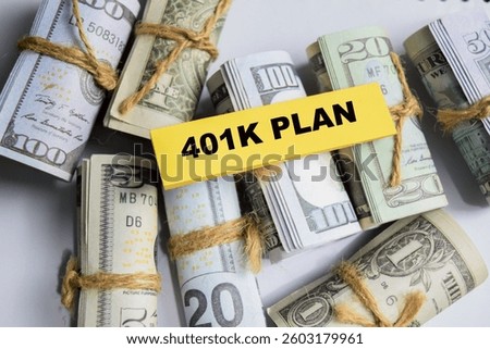 Concept of 401K Plan write on sticky and dollars notes isolated on Wooden Table.