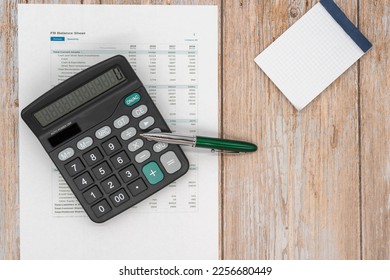 The concept of an accounting audit. calculator and magnifying glass on the financial statement and the annual balance sheet on the auditor's desk. - Shutterstock ID 2256680449
