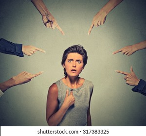 Concept of accusation guilty person girl. Upset angry looking woman asking me? many fingers pointing at her isolated on grey office wall background. Human face expression emotion feeling reaction