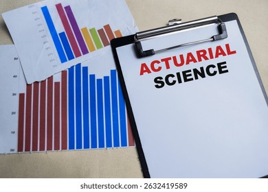 Concept of Actuarial science write on clipboard isolated on Wooden Table.