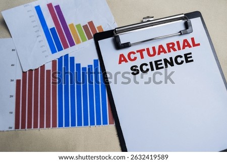 Concept of Actuarial science write on clipboard isolated on Wooden Table.