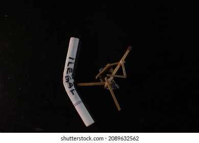 The Concept Of Addiction In Smoking, Smokers Want To Quit Smoking. Image Of A Character Made Of Cigarettes, It Says Illegal Cigarettes On A Black Background. Cigarette Butts On A Black Background.