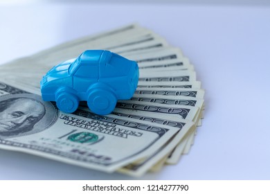 Concept for advertising loan, collateral, pawnshop, car rental. Money and cars. An idea to illustrate buying a car in installments or as collateral. Toy car and real dollar bills.