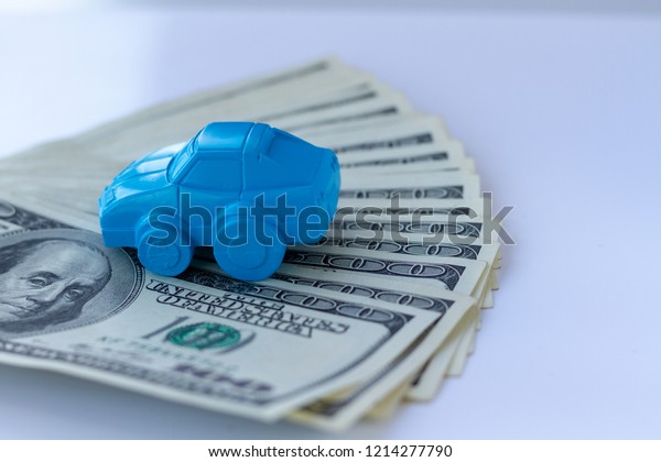 Concept for\
advertising loan, collateral, pawnshop, car rental. Money and cars.\
An idea to illustrate buying a car in installments or as\
collateral. Toy car and real dollar\
bills.