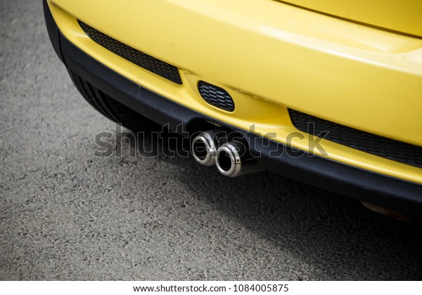 Concept - air pollution from exhaust gases from a\
car in the city.