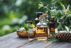 Concept Of Alternative Herbal Medicine. Bottles Of Tincture Or Potion, Organic Essential Oils, Dry Healthy Herbs, Floral Extracts On Wooden Table. Pure Natural Ingredients For Cosmetic Production