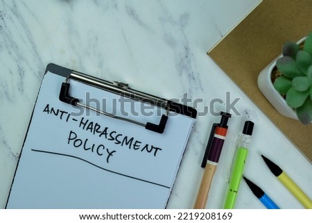 Concept of Anti-Harassment Policy write on paperwork with statistics isolated on Wooden Table.