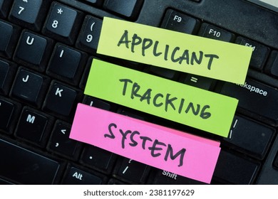 Concept of Applicant tracking System write on sticky notes isolated on Wooden Table.