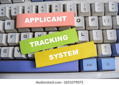 Concept of Applicant, tracking, and system write on sticky notes isolated on keyboard.