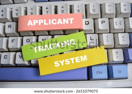 Concept of Applicant, tracking, and system write on sticky notes isolated on keyboard.