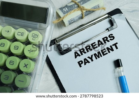 Concept of arrears payment write on clipboard isolated on Wooden Table.
