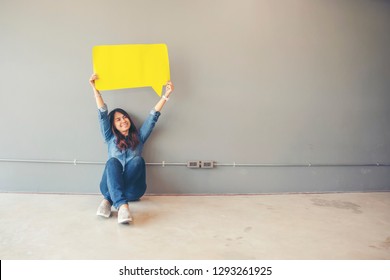 Concept of Asian people holding banner and placard (speech and Message bubble). Beautiful young girl wearing fashion shirt and jean with Blank text bubble, grey background. - Shutterstock ID 1293261925