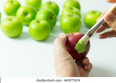 Concept of assimilation by painting red apple into green color