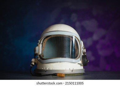 Concept of astronaut helmet on the table on the cosmic background.