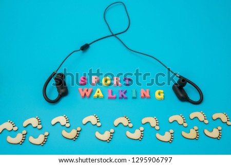 The concept of athletic walking. footprints on a blue background and the word race walking and headphones.