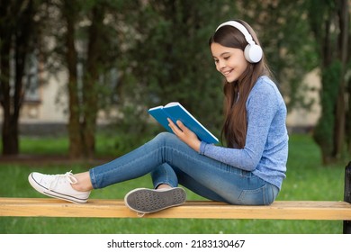 Concept Of Audiobook. Happy Girl Teenager Reading And Listening To Audiobook