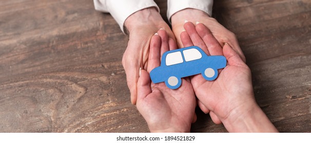 Concept Of Auto Insurance With Paper Car In Hands