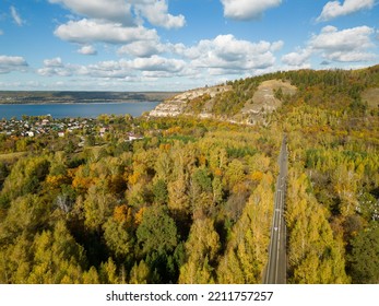 The Concept Of Autumn. Bird's-eye View Of The Road Through The Forest To The Mountains. The Path To The Dream. A Country Road Through A Dense Forest Leads Uphill. Journey. A Picture From A Drone