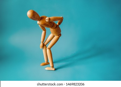 Concept of back pain. A wooden figure depicts a pain in the back. - Powered by Shutterstock