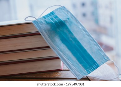 Concept Of Back To School With Prevention In The New Normal. Books And Medical Mask On The Table