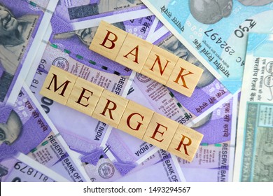 Concept Of Bank Merger In Wooden Blocks On Indian Currency Notes.