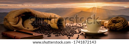 Concept Banner,Many coffee beans are laid on wooden barrels and all around, and there are coffee cups with notebooks and pencils on wooden tables, with a backdrop of high mountain views in the morning